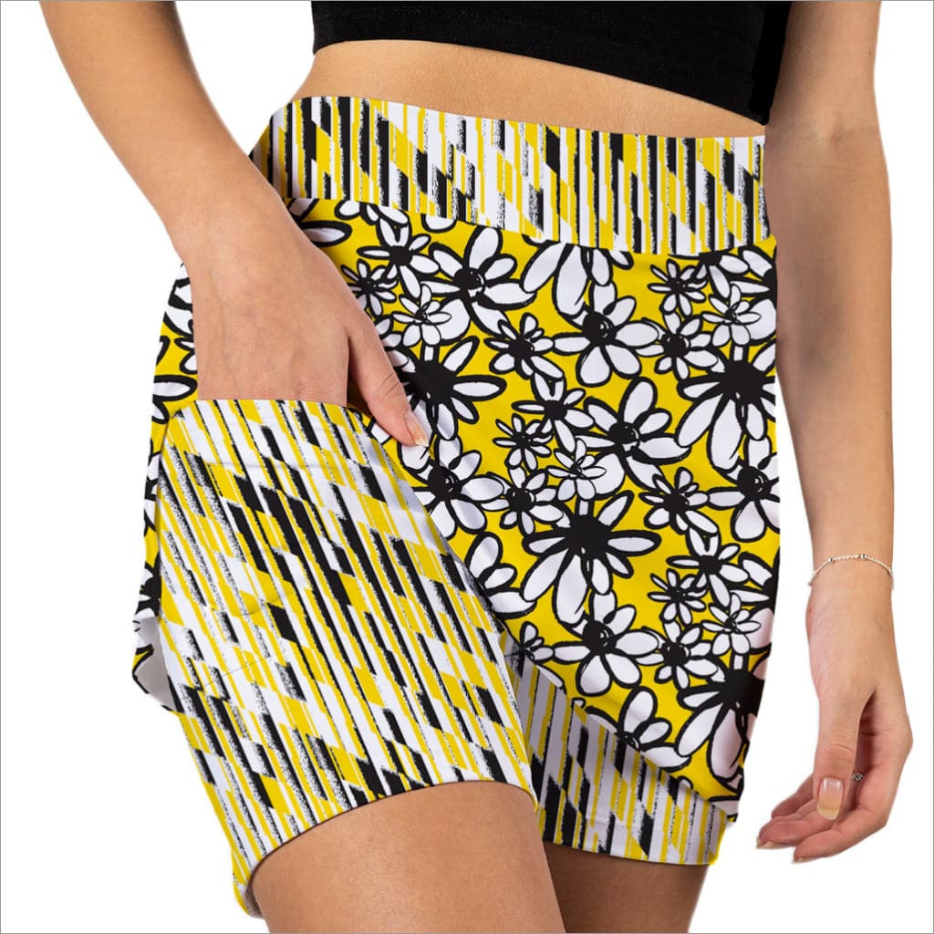Yellow shorts with black and white floral pattern worn by a person on a white background
