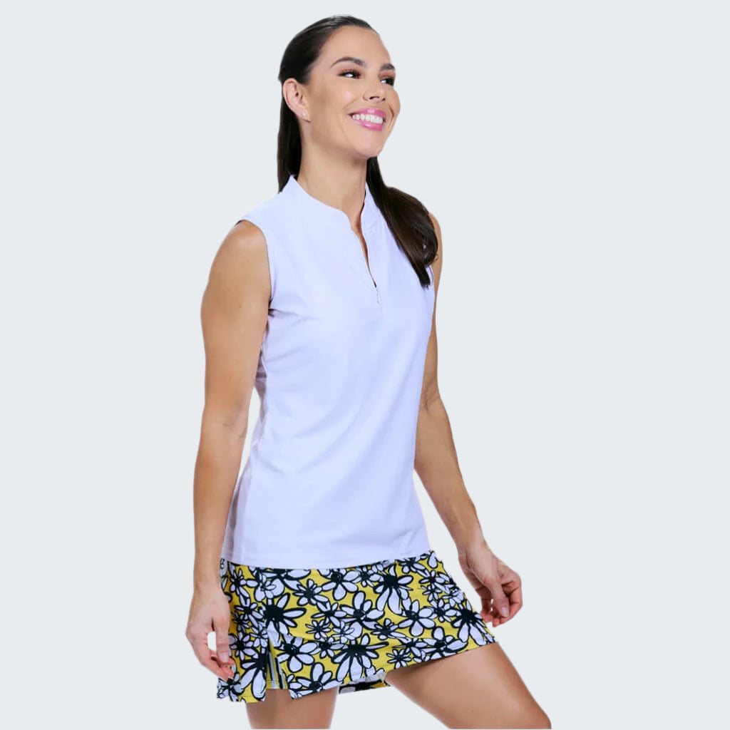 Woman wearing a light blue sleeveless top and a floral skirt on a plain background