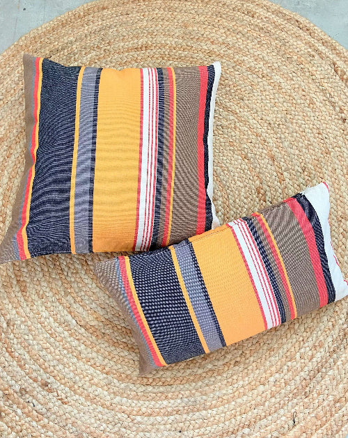 Two striped pillows on a woven mat