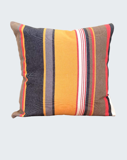 Striped pillow with multicolor pattern on a wooden stool against a plain background