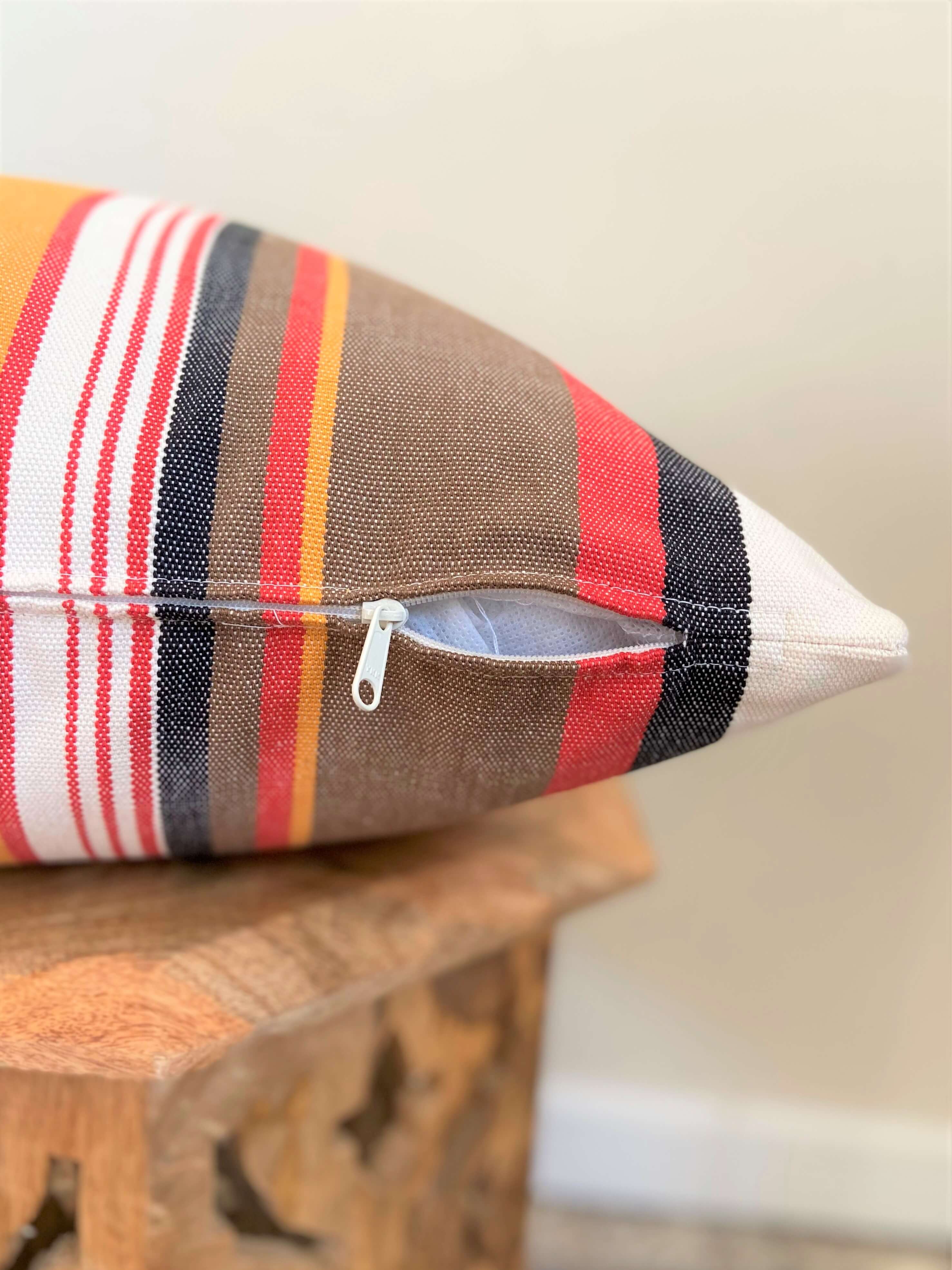 Striped pillow with a zipper on a wooden surface