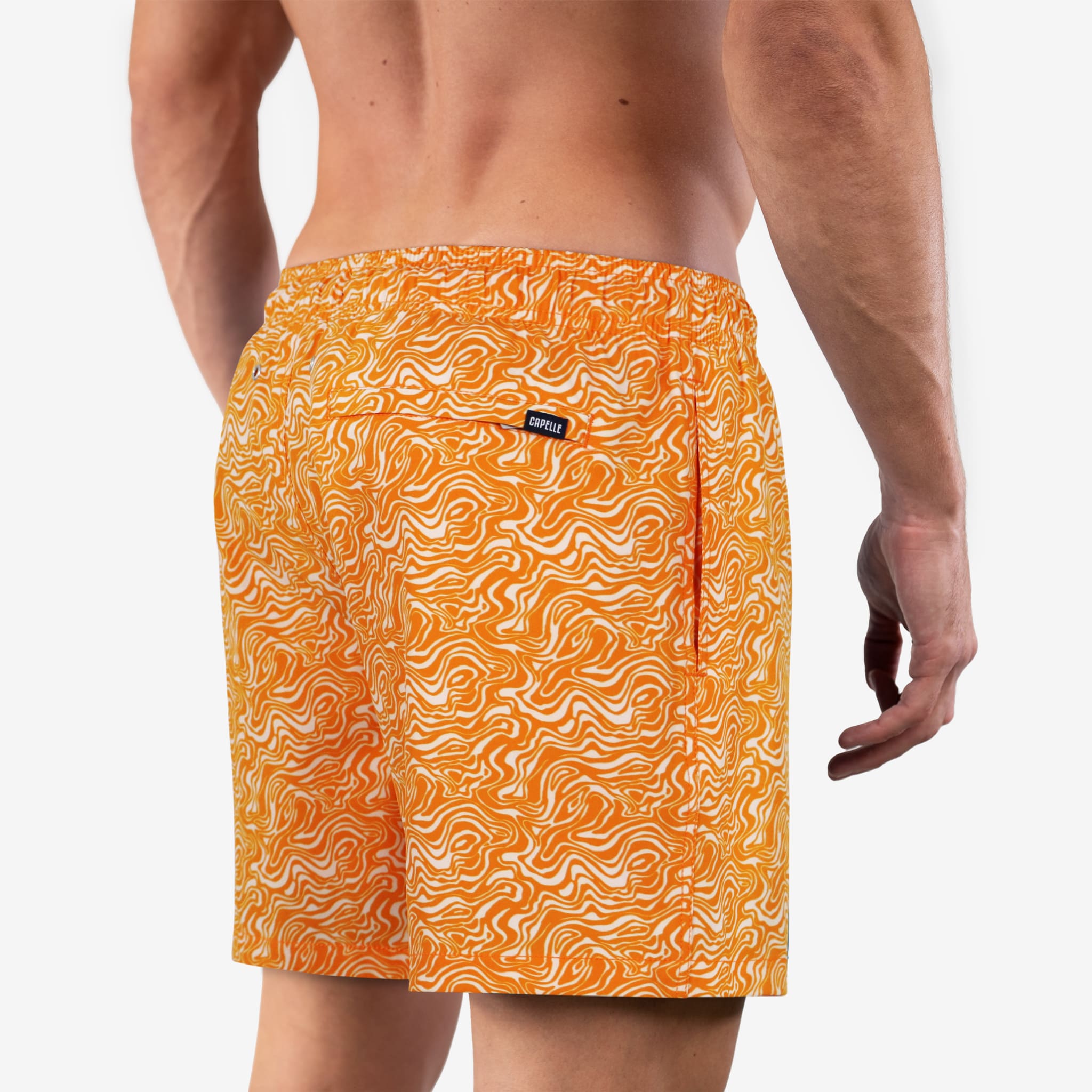 Orange patterned swim shorts worn by a person on a white background