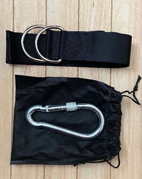 Black belt with silver D-ring and carabiner on a wooden surface
