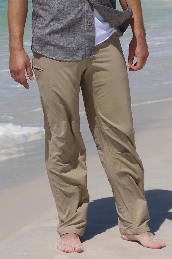 Person wearing beige pants and a gray shirt on a beach.