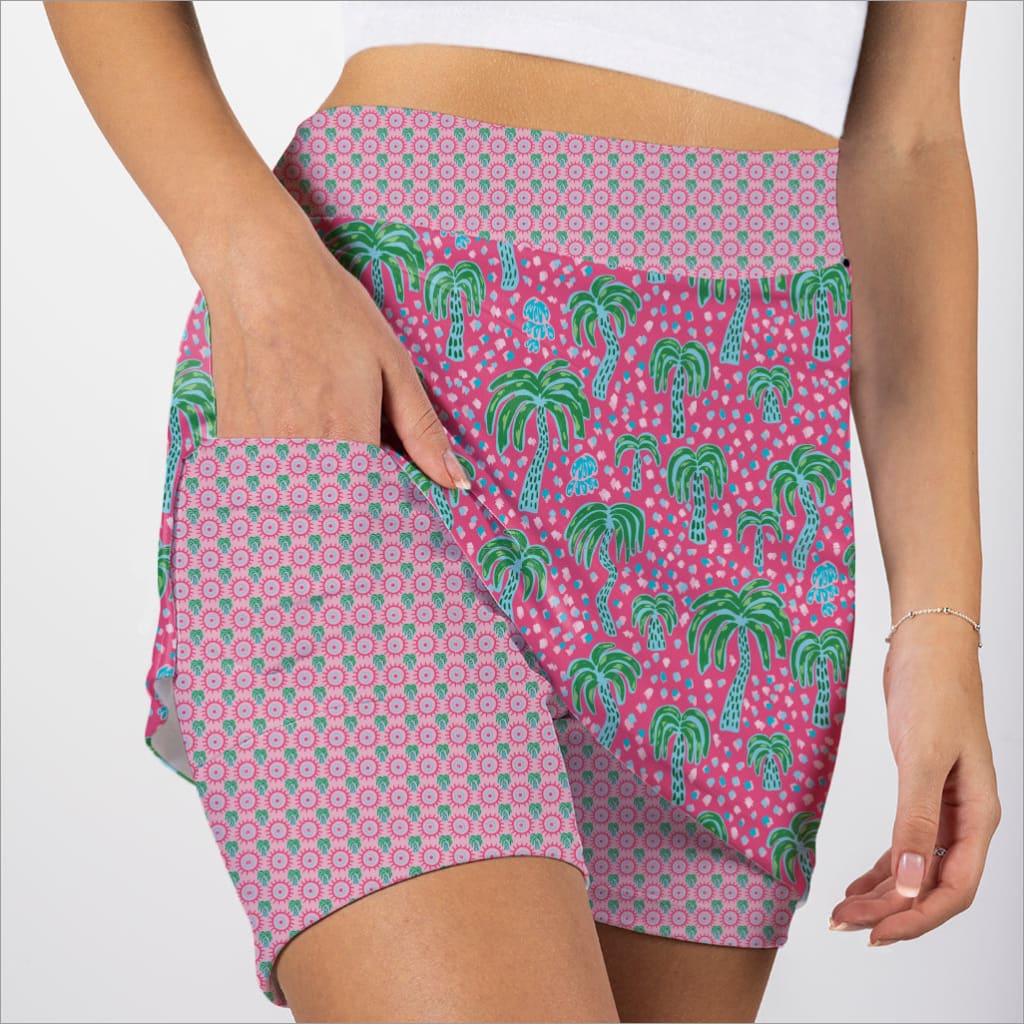 Pink shorts with green palm tree pattern on a white background