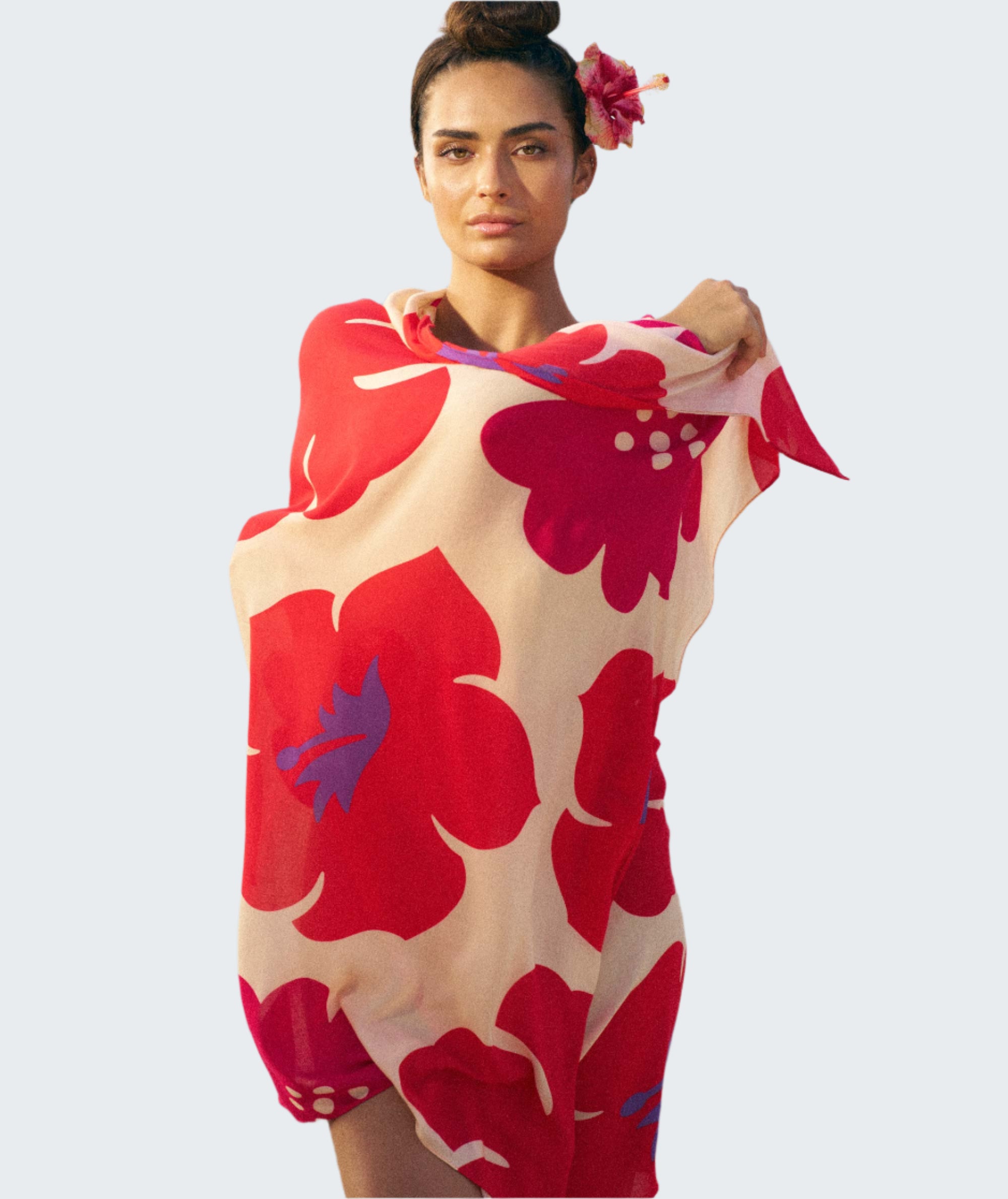Woman on a beach wearing a red and white floral towel