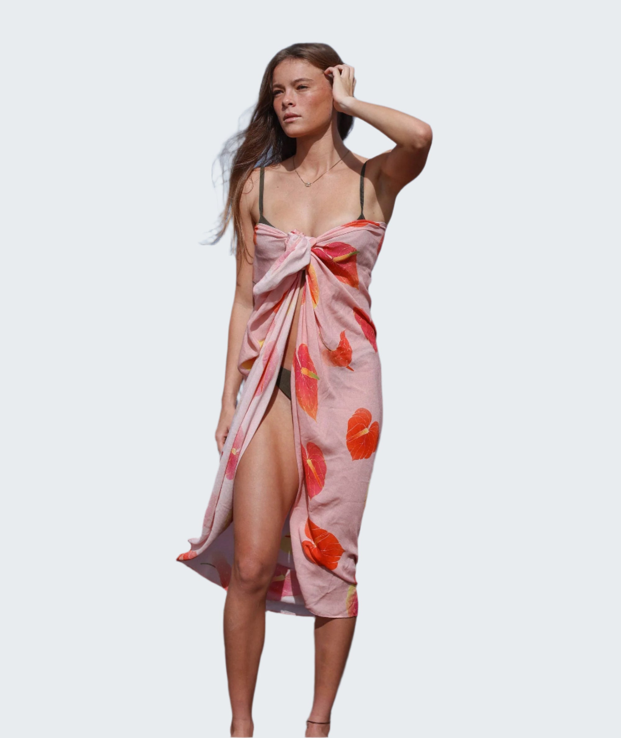 Woman in a colorful dress standing on rocks by the ocean