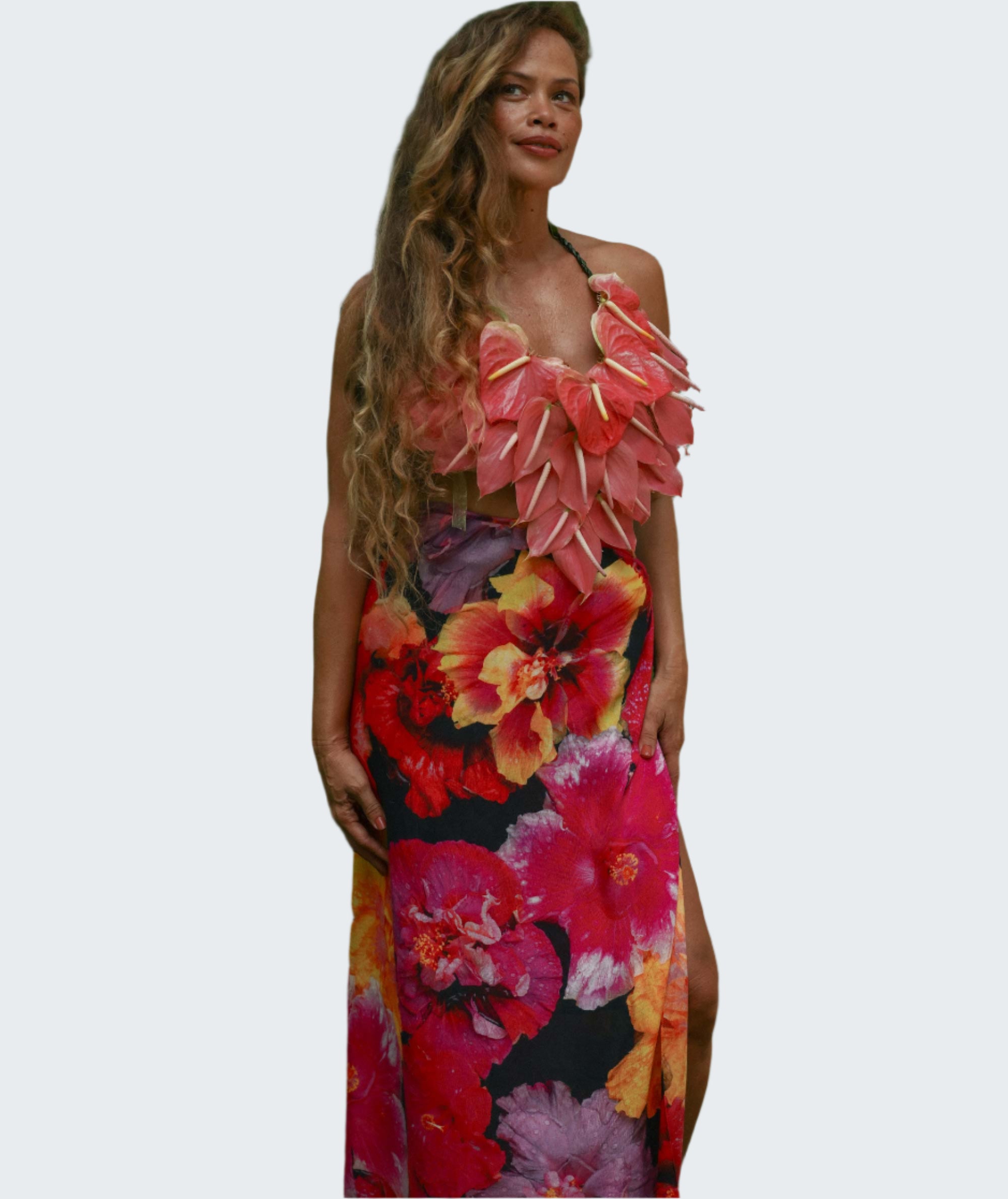 Woman wearing a colorful floral dress standing in a forest setting