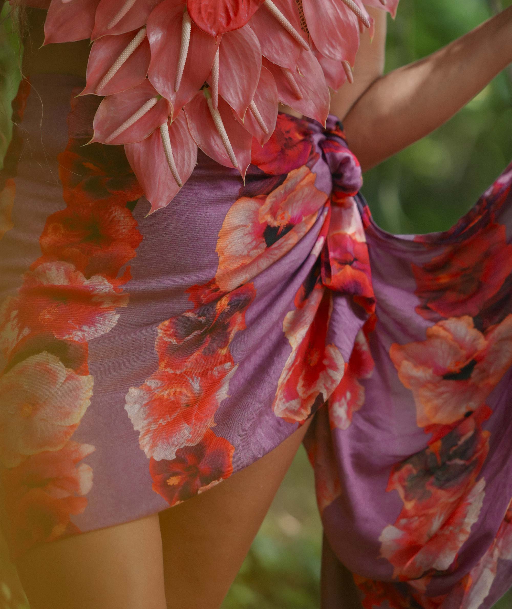 Person wearing a colorful floral dress with a blurred natural background
