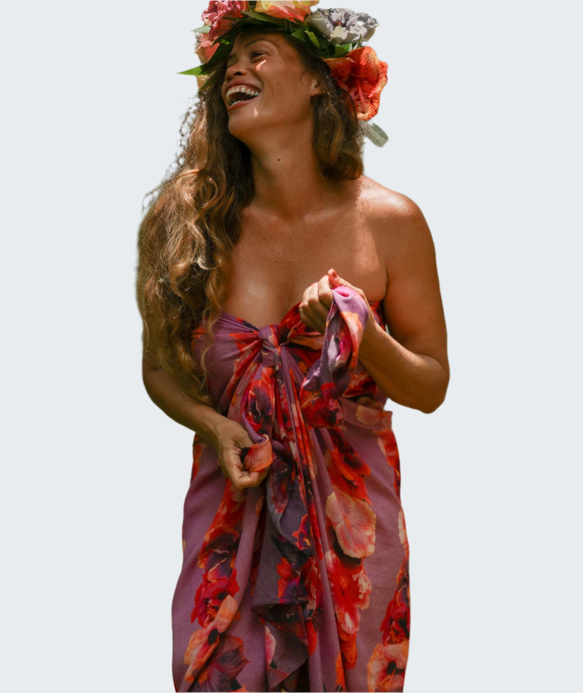 Woman in a floral dress and headpiece standing outdoors with greenery in the background