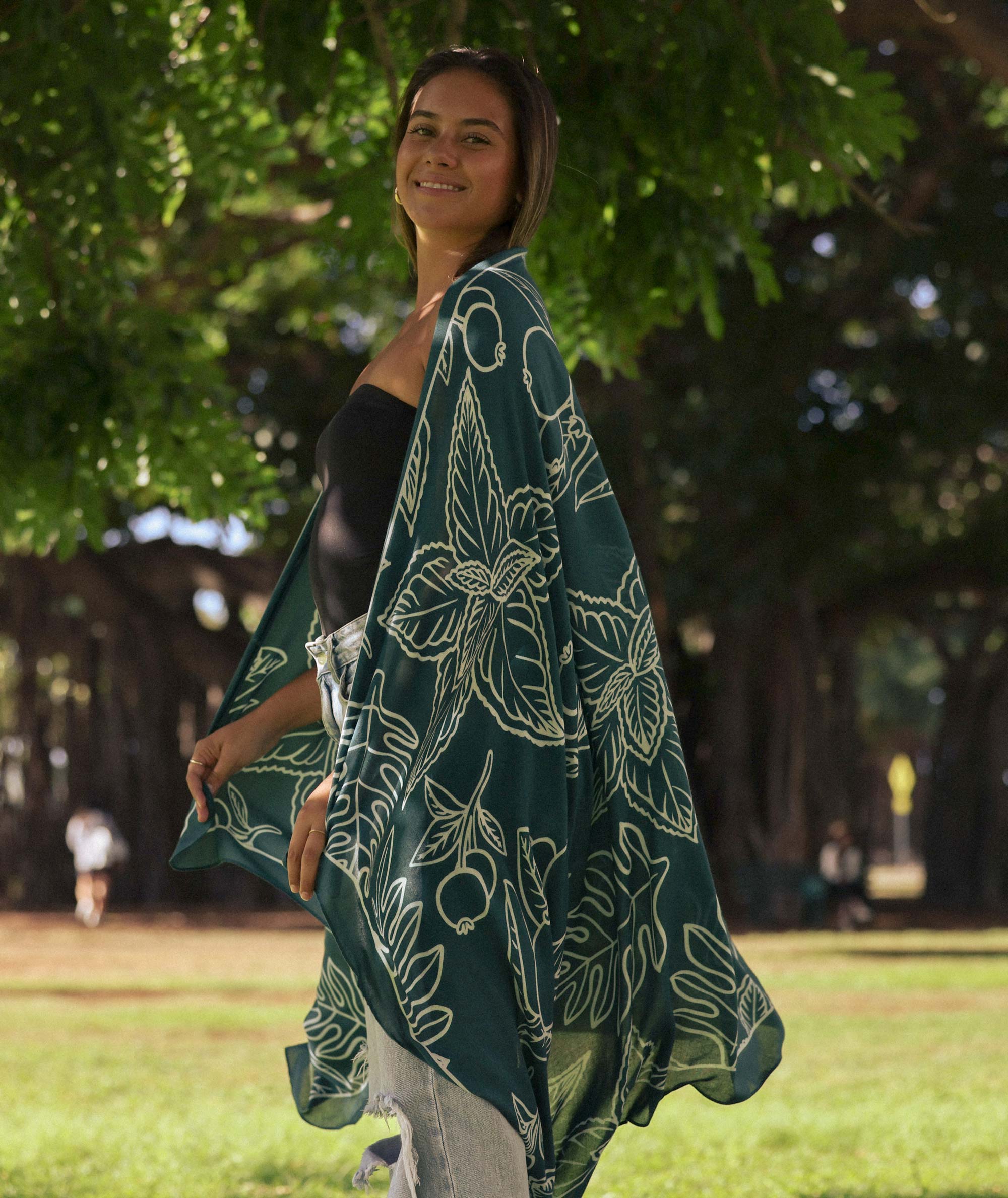 Woman wearing a green patterned shawl in a park
