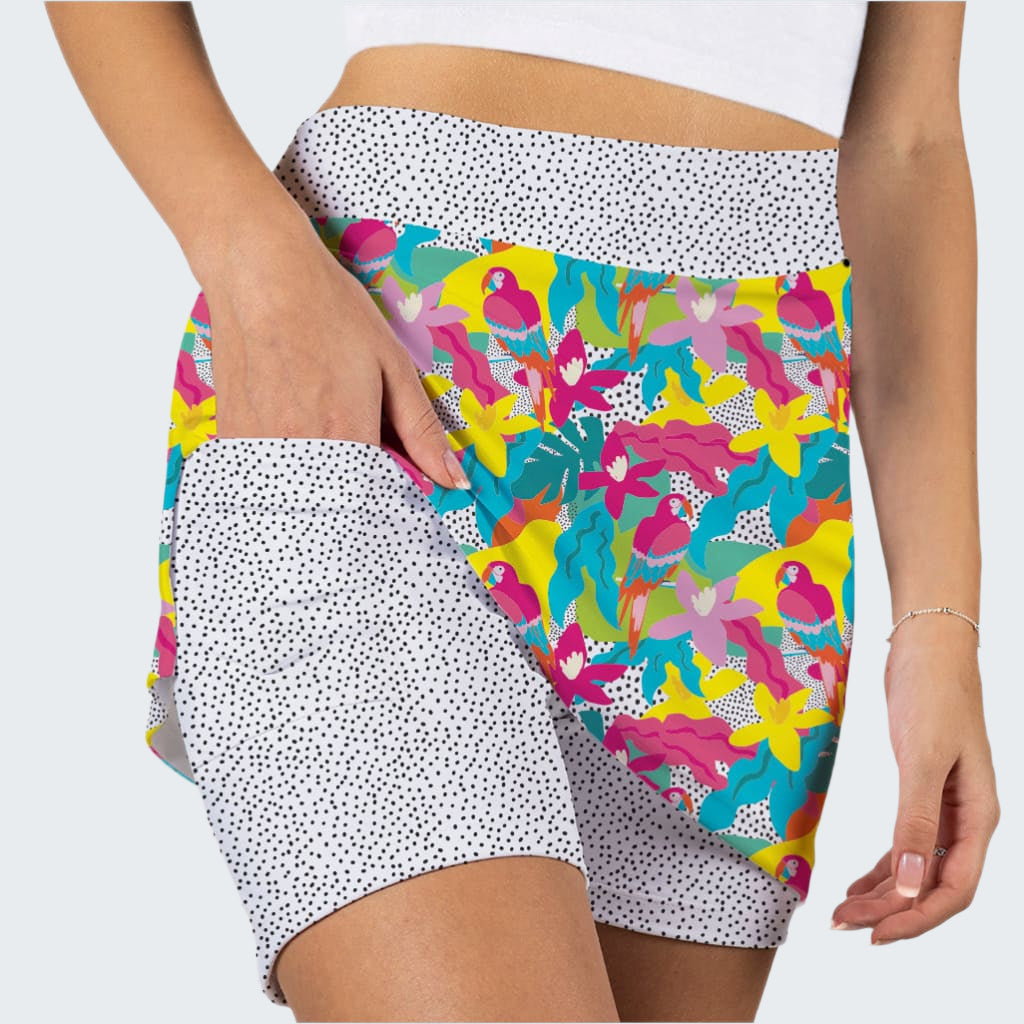 Colorful patterned shorts with white polka dot trim on a plain background