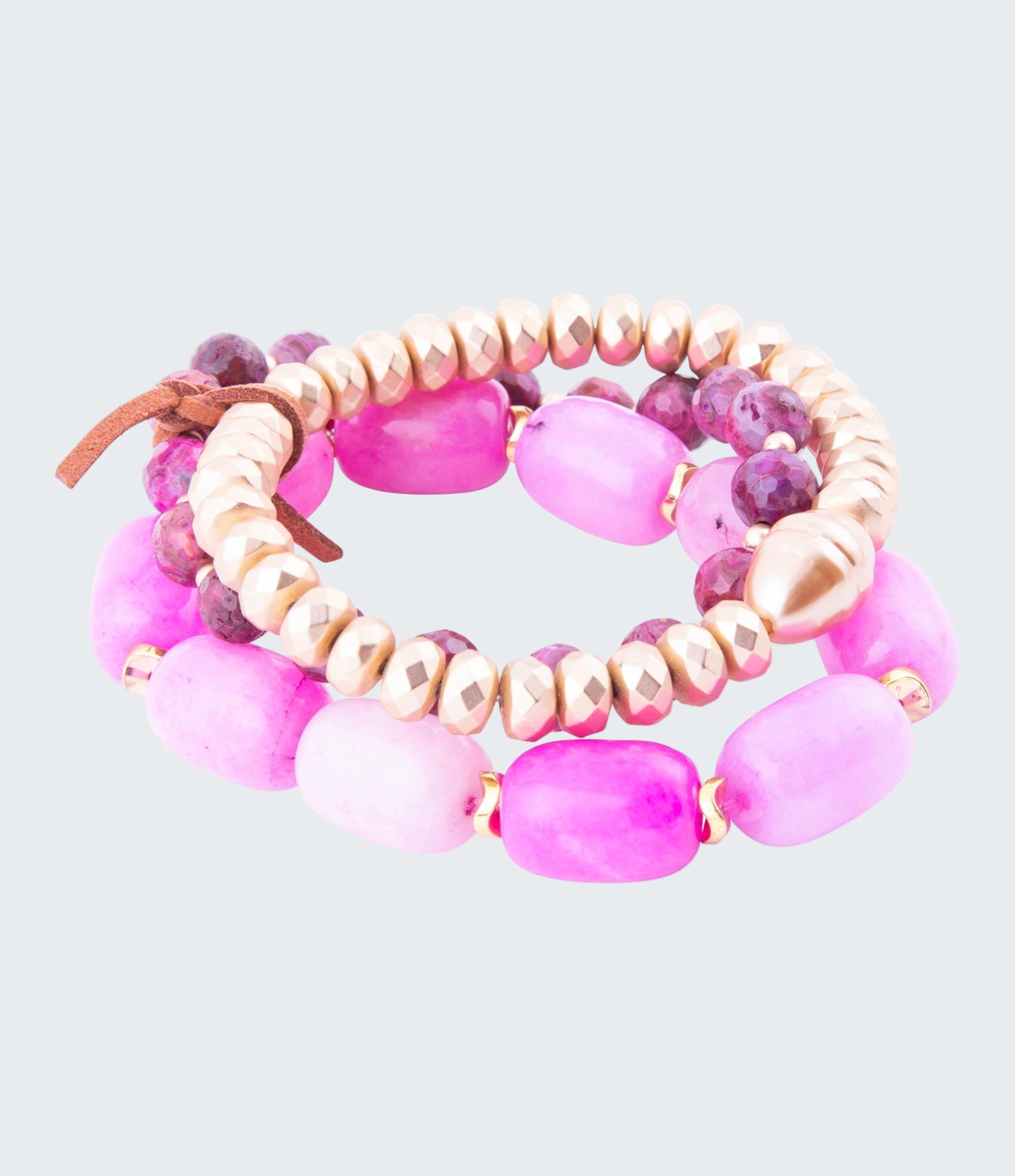 Set of pink and beige beaded bracelets on a white background