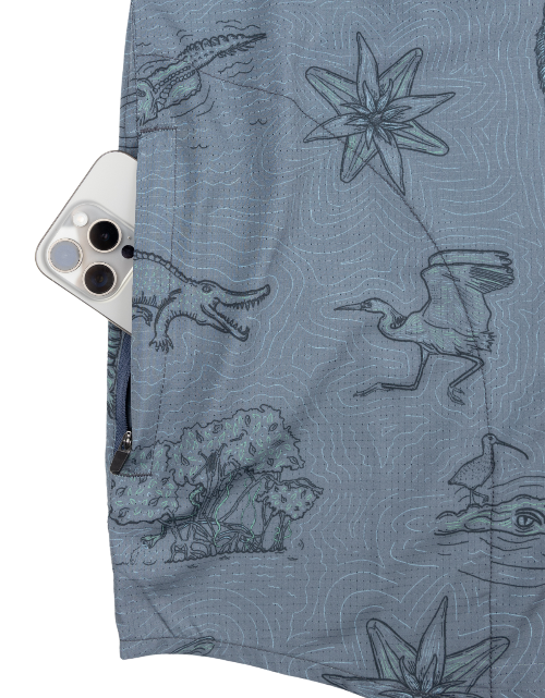 Blue shirt with nature-themed design featuring animals and plants, with a phone case on the sleeve.