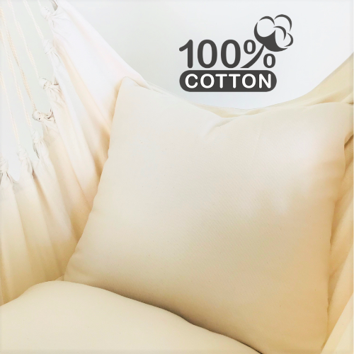 Beige pillow with '100% Cotton' label on a blurred background