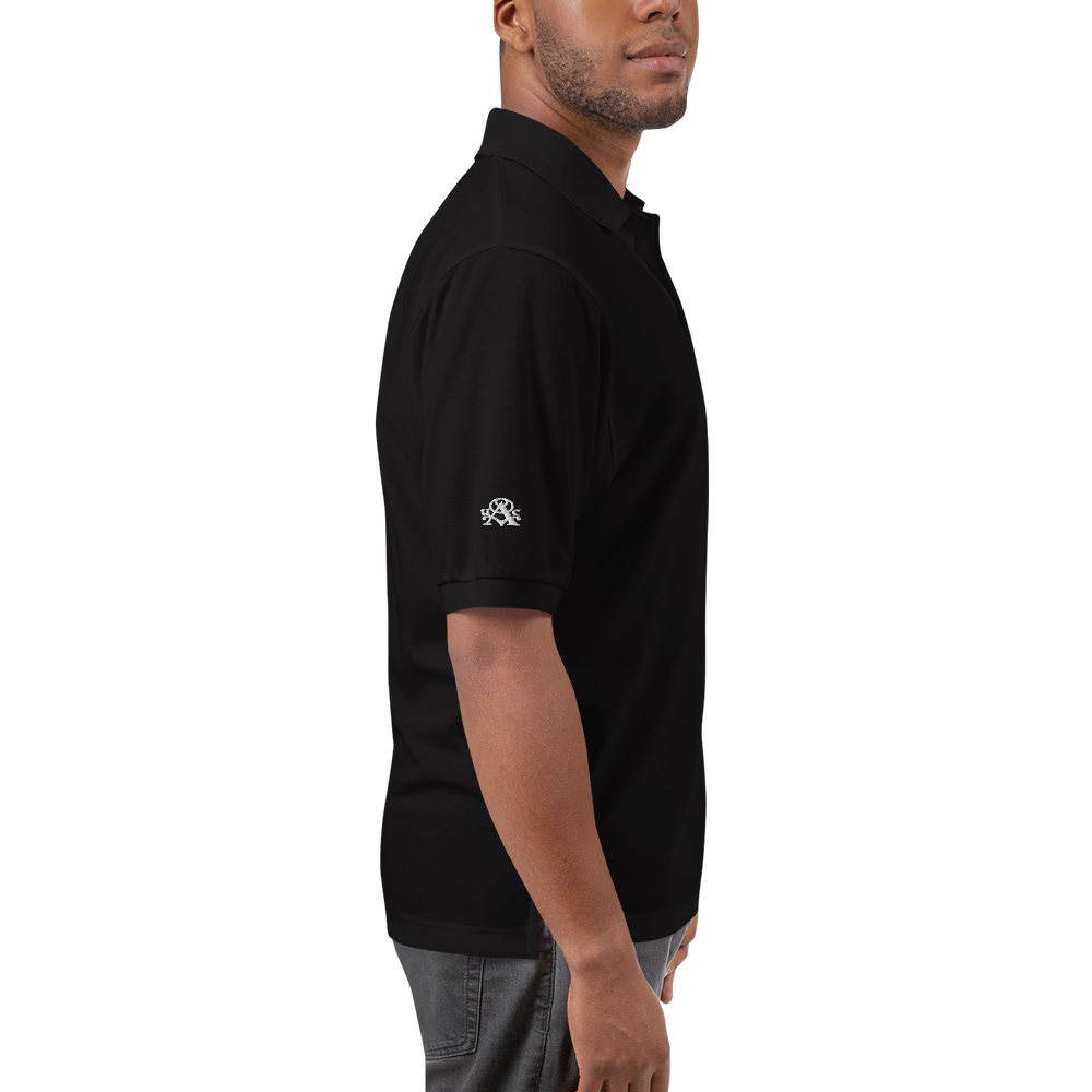 Man wearing a black polo shirt with a logo on the sleeve against a white background