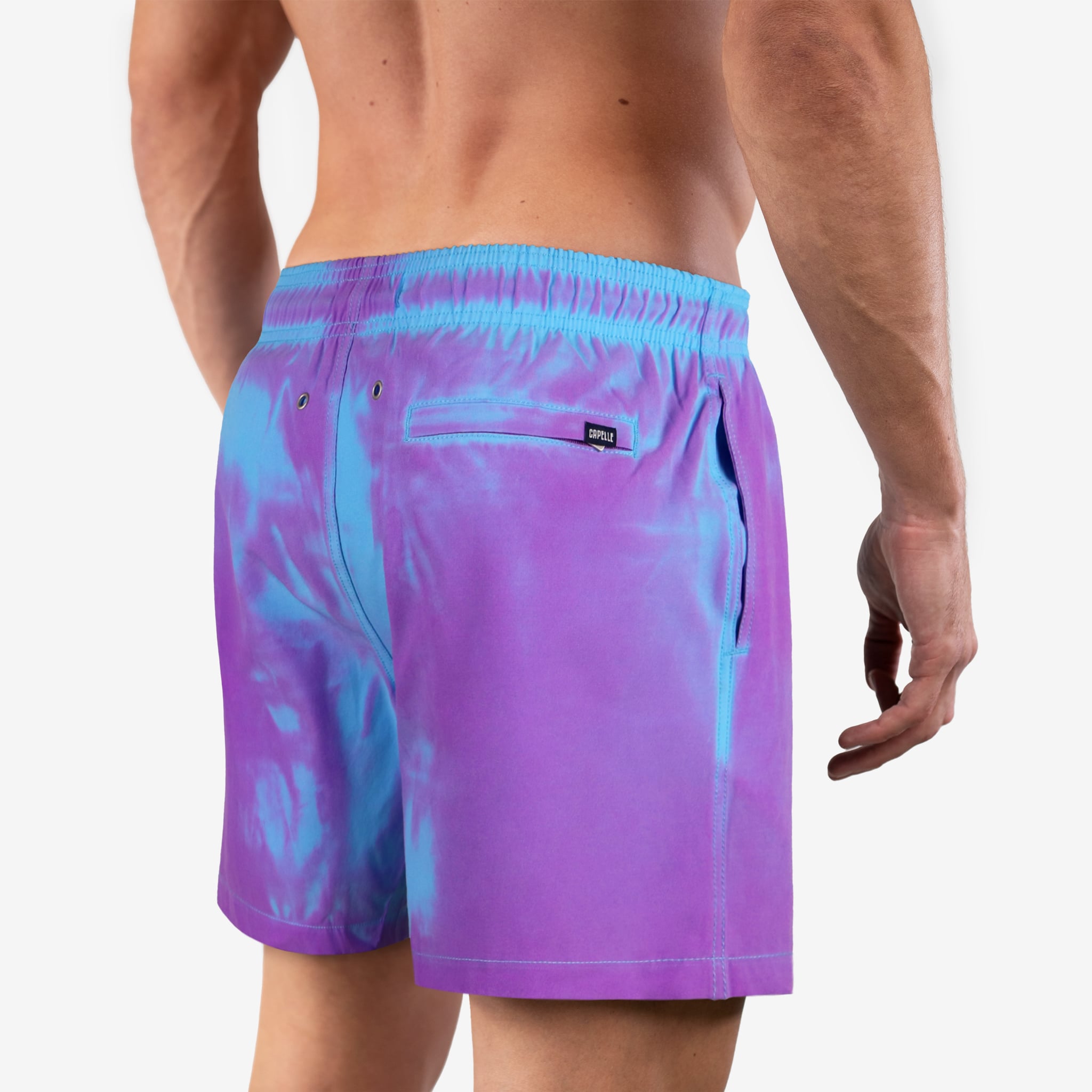 Purple and blue tie-dye swim shorts on a plain background