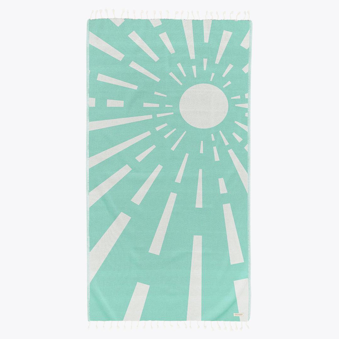 Teal towel with white sunburst pattern on a white background