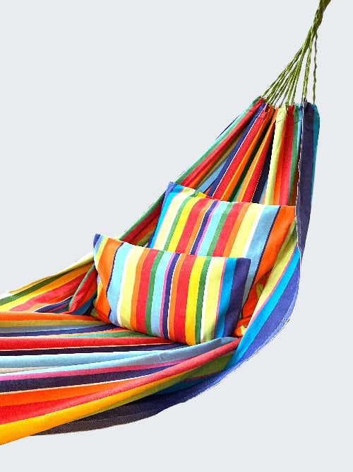 Colorful striped hammock on a wooden deck with a scenic background
