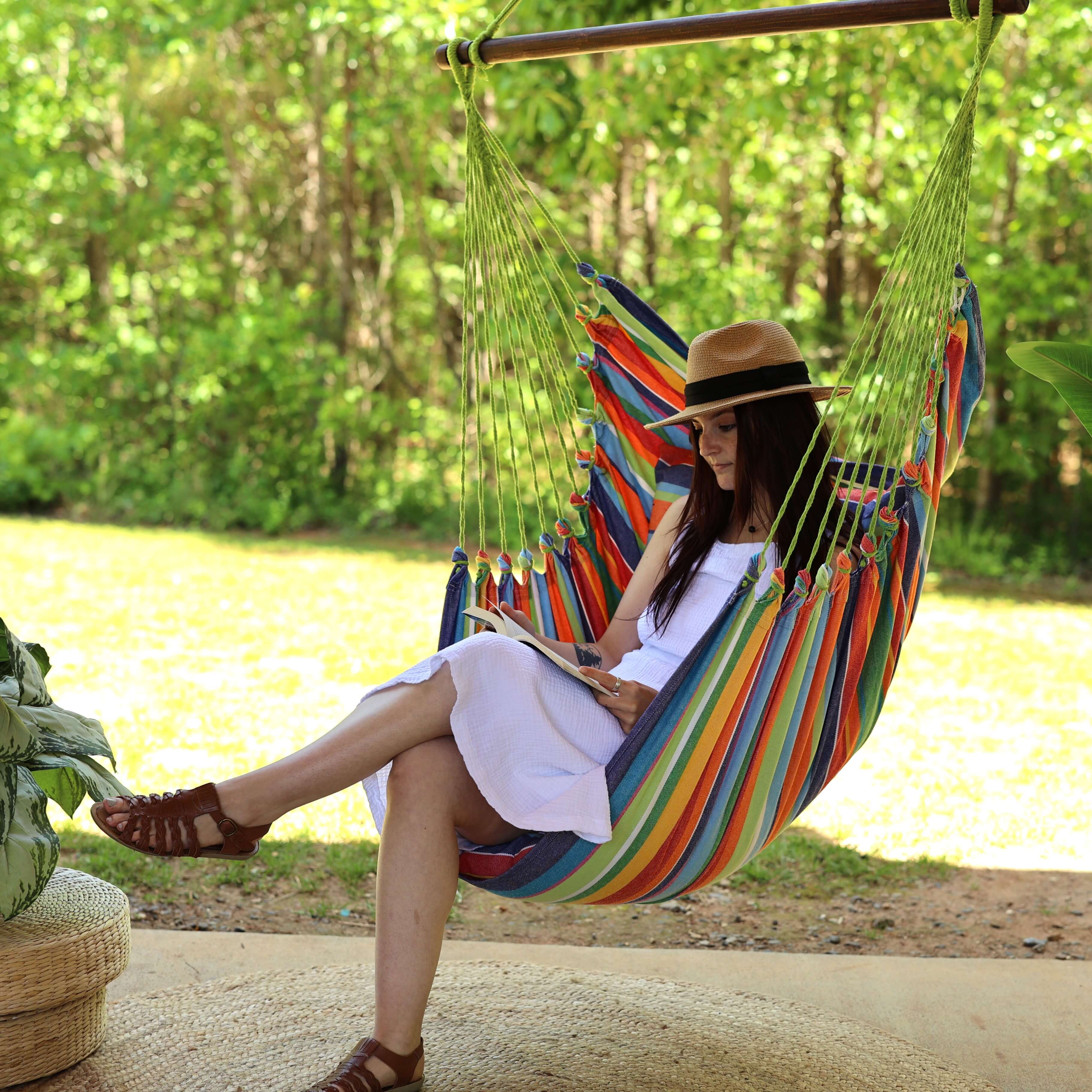 Woman sitting in a colorful hammock in a forest setting