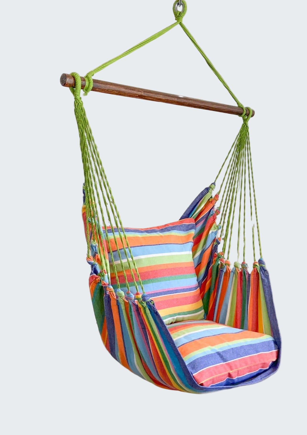 Colorful striped hammock chair hanging in a room with decorative elements.