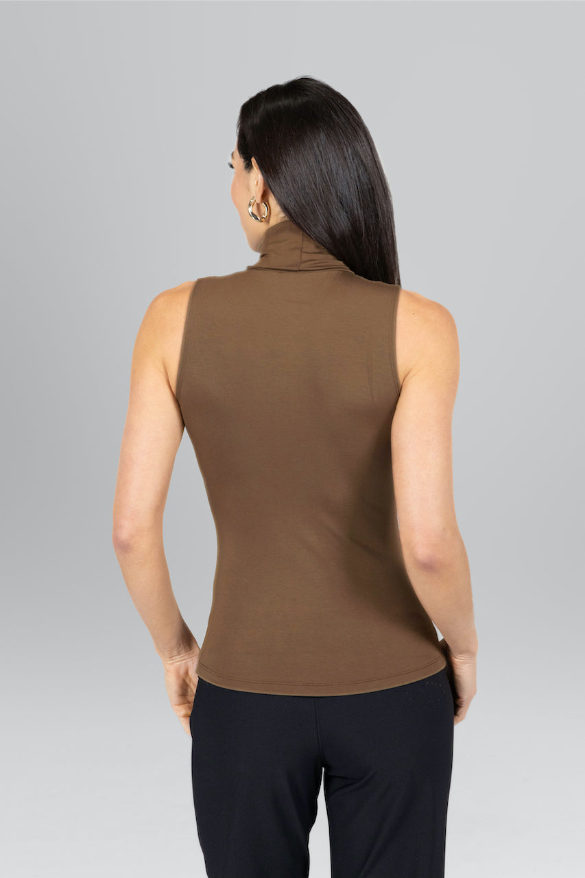 Woman wearing a brown sleeveless top against a gray background