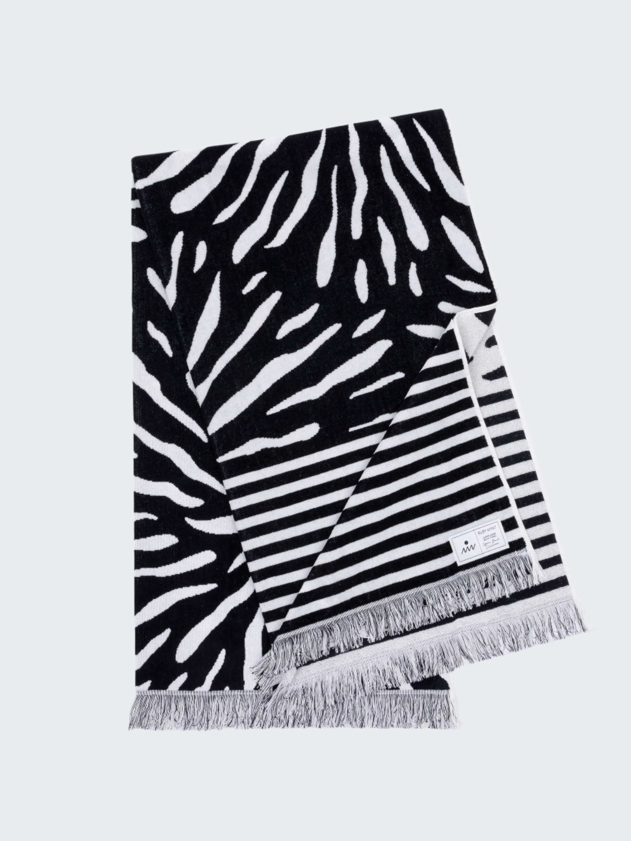 Black and white patterned towel with fringes on a white background