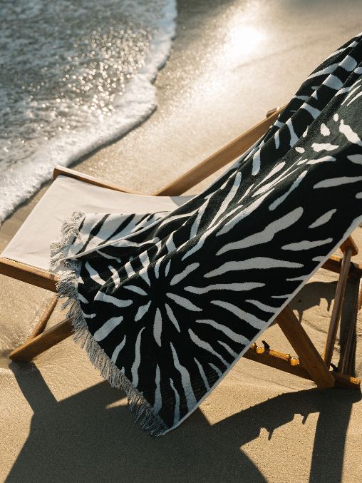 Black and white patterned towel on a beach chair by the ocean
