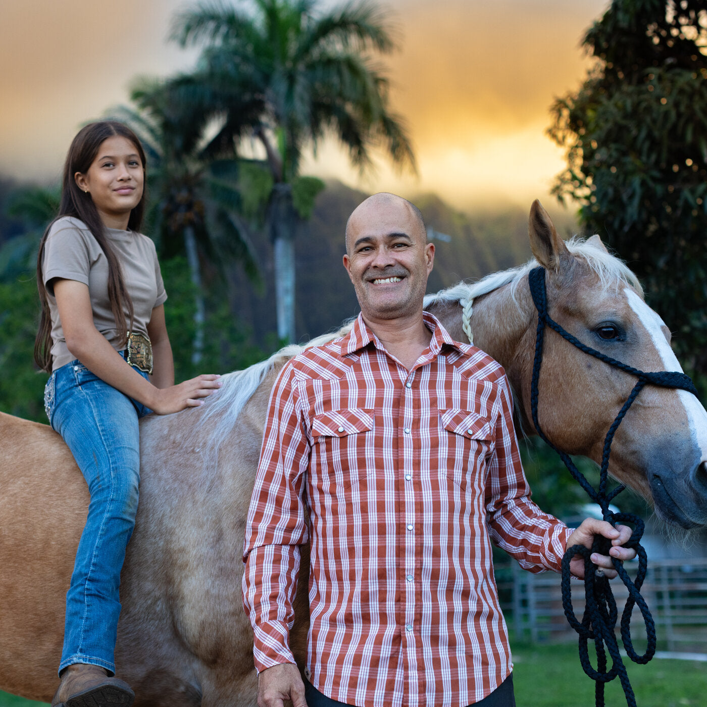 Man and young girl with a horse at sunset