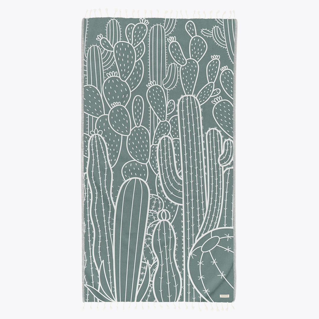Teal towel with white cactus pattern on a white background
