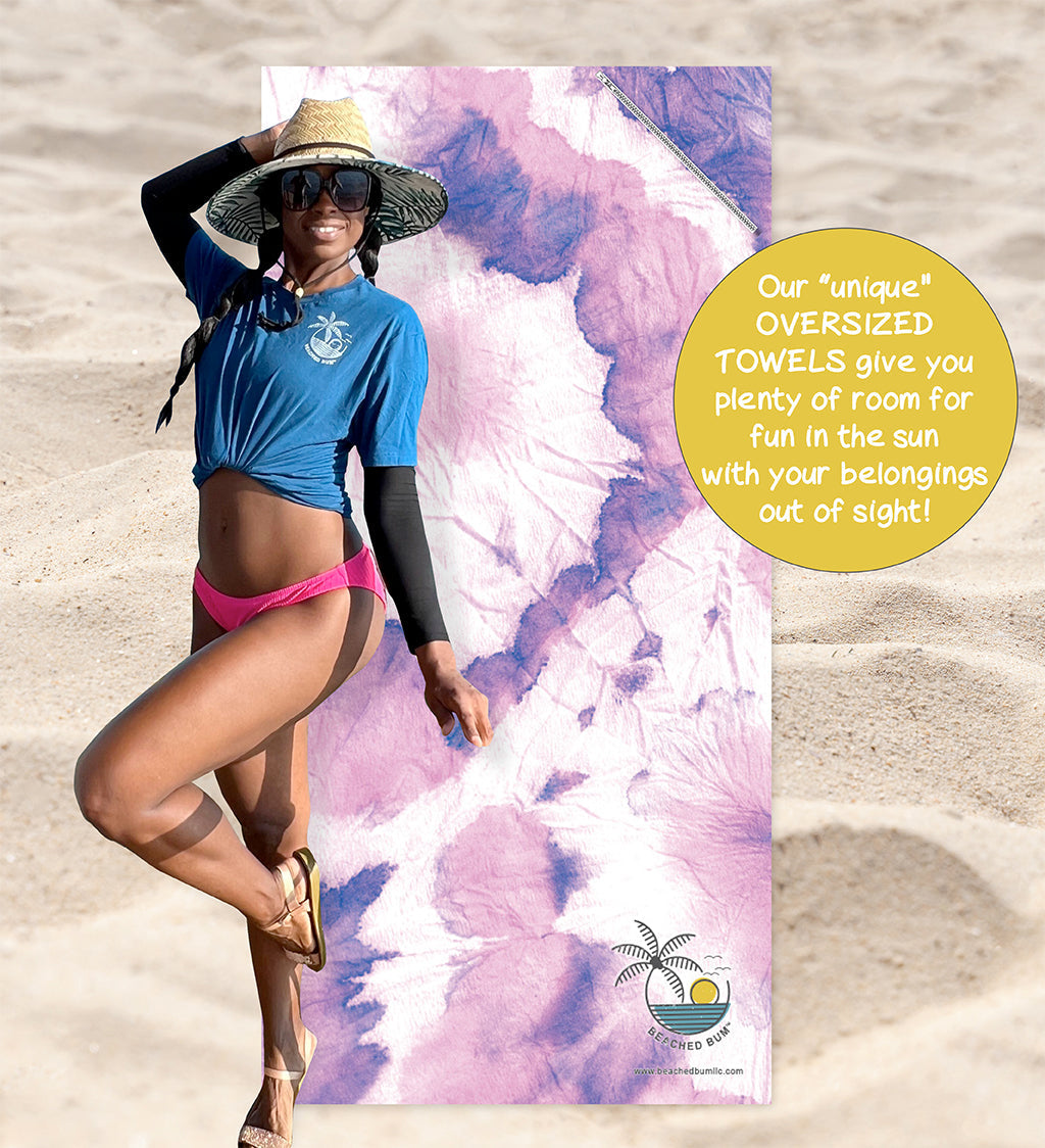 Woman on a beach with a towel featuring a palm tree design, promotional text about oversized towels.