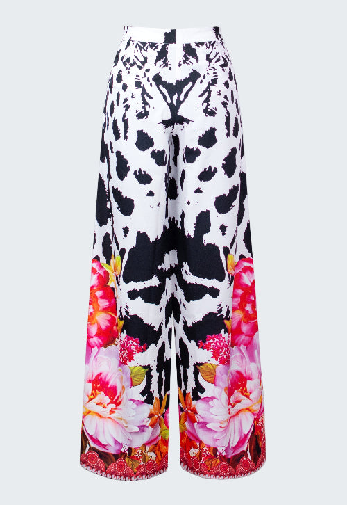 Wide-leg pants with black and white abstract pattern and colorful floral design on a white background