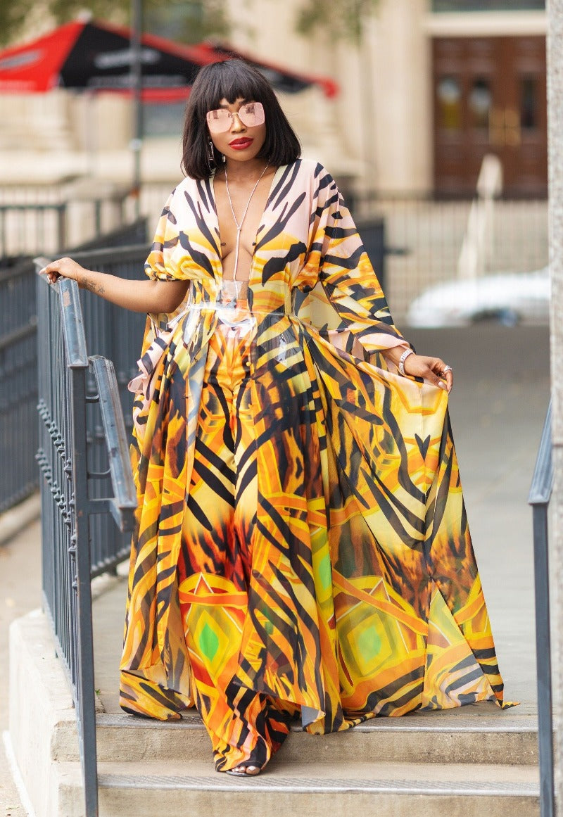 Woman in a vibrant, patterned dress standing on steps outdoors.