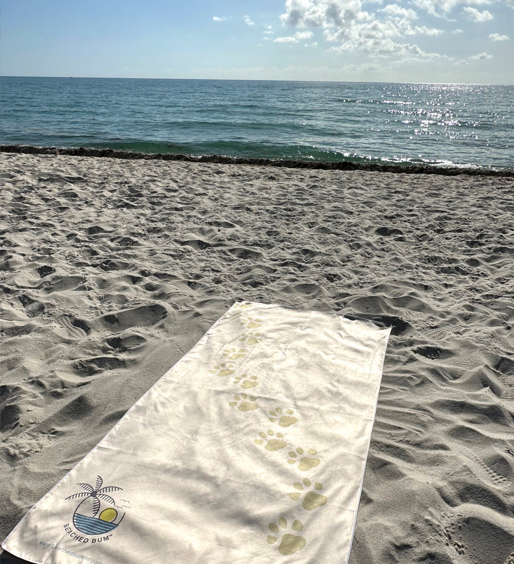 Beach towel with a logo on sand by the ocean
