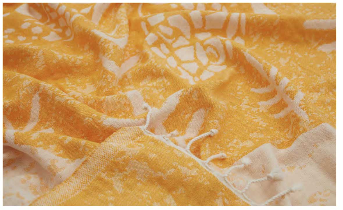 Close-up of yellow fabric with white floral patterns