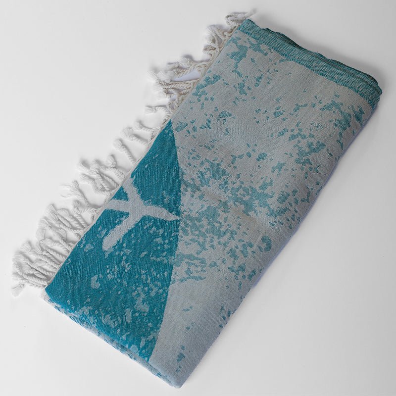 Folded towel with blue and gray pattern on a white background