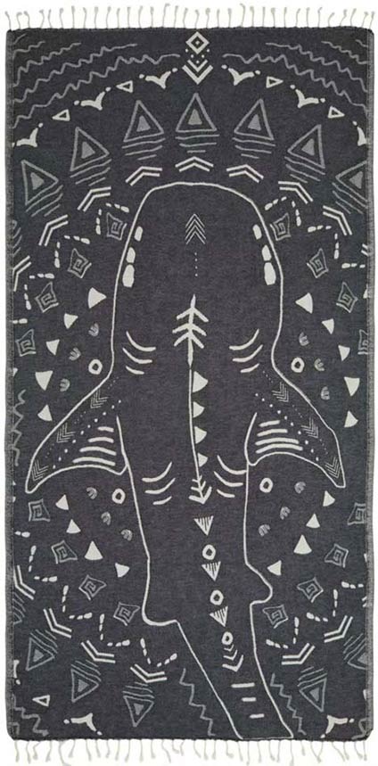 Black rug with white abstract patterns and a central design of a stylized figure.