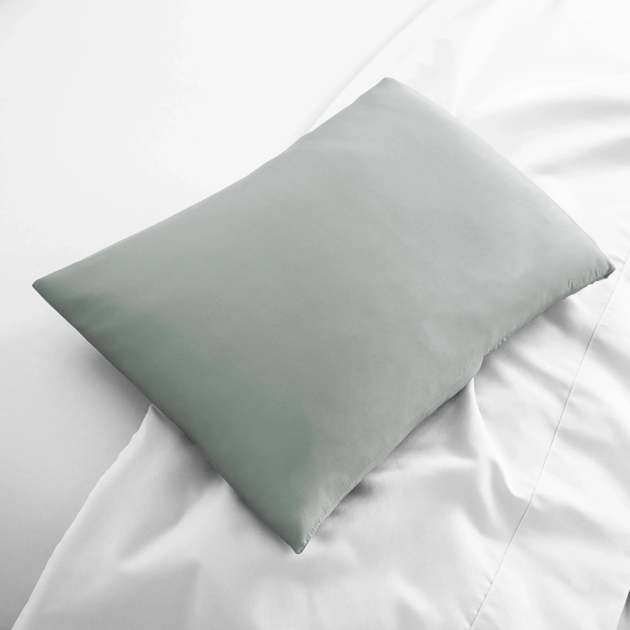 Gray pillow on a white bed
