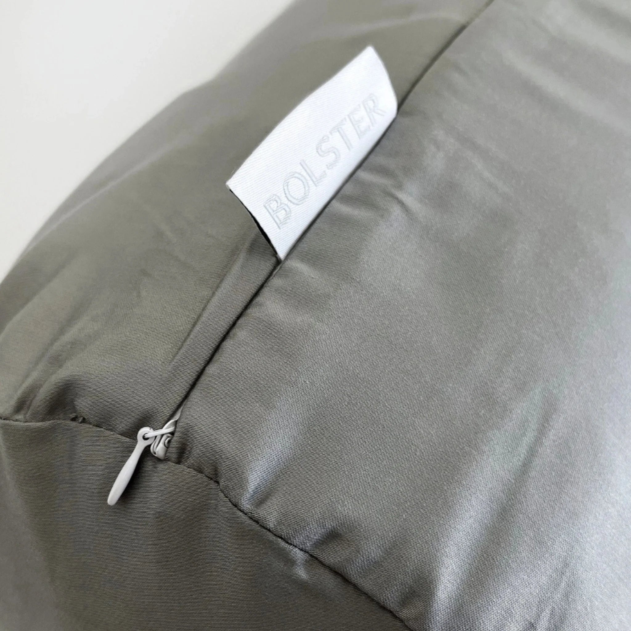 Gray pillow with a brand label on a white background