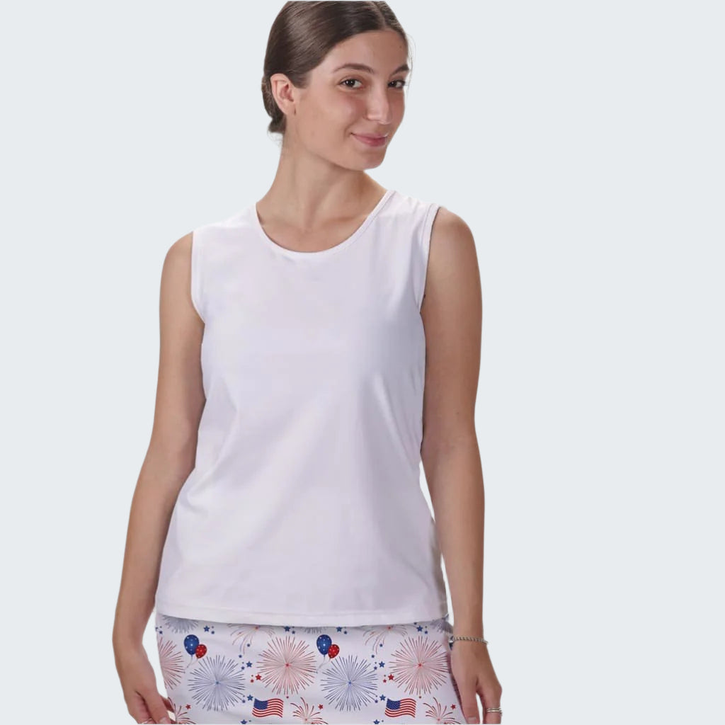 Woman wearing a white sleeveless top and patterned shorts on a plain background