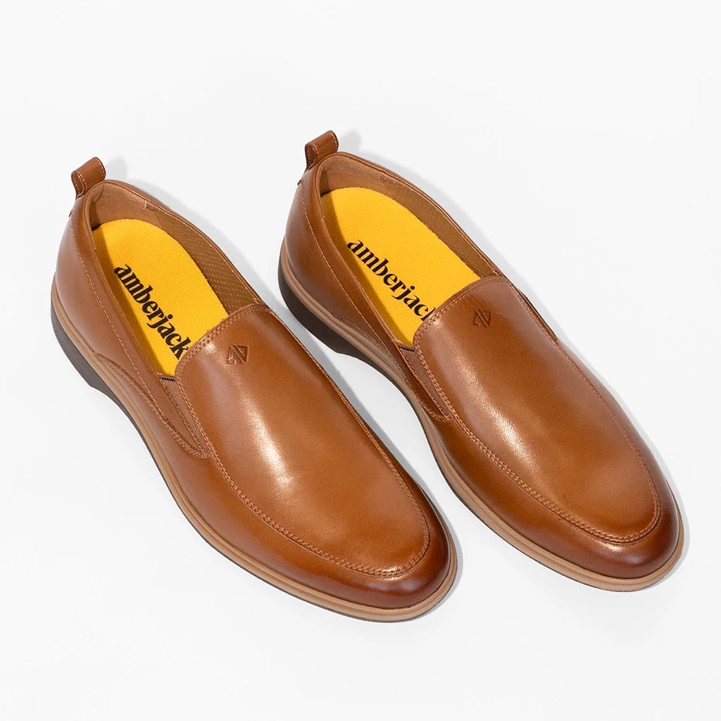 Pair of brown leather shoes with yellow insole on a white background