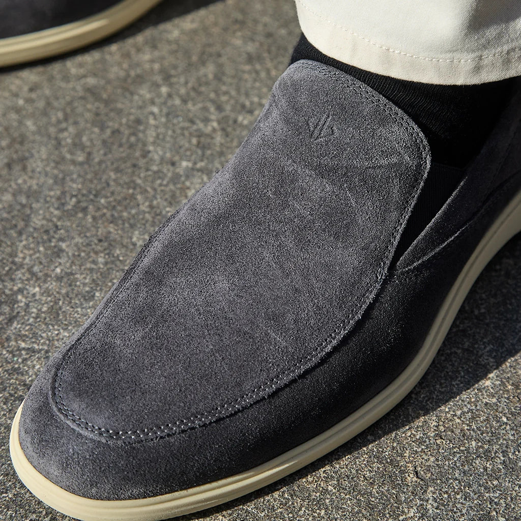 Gray suede loafer shoe on a concrete surface