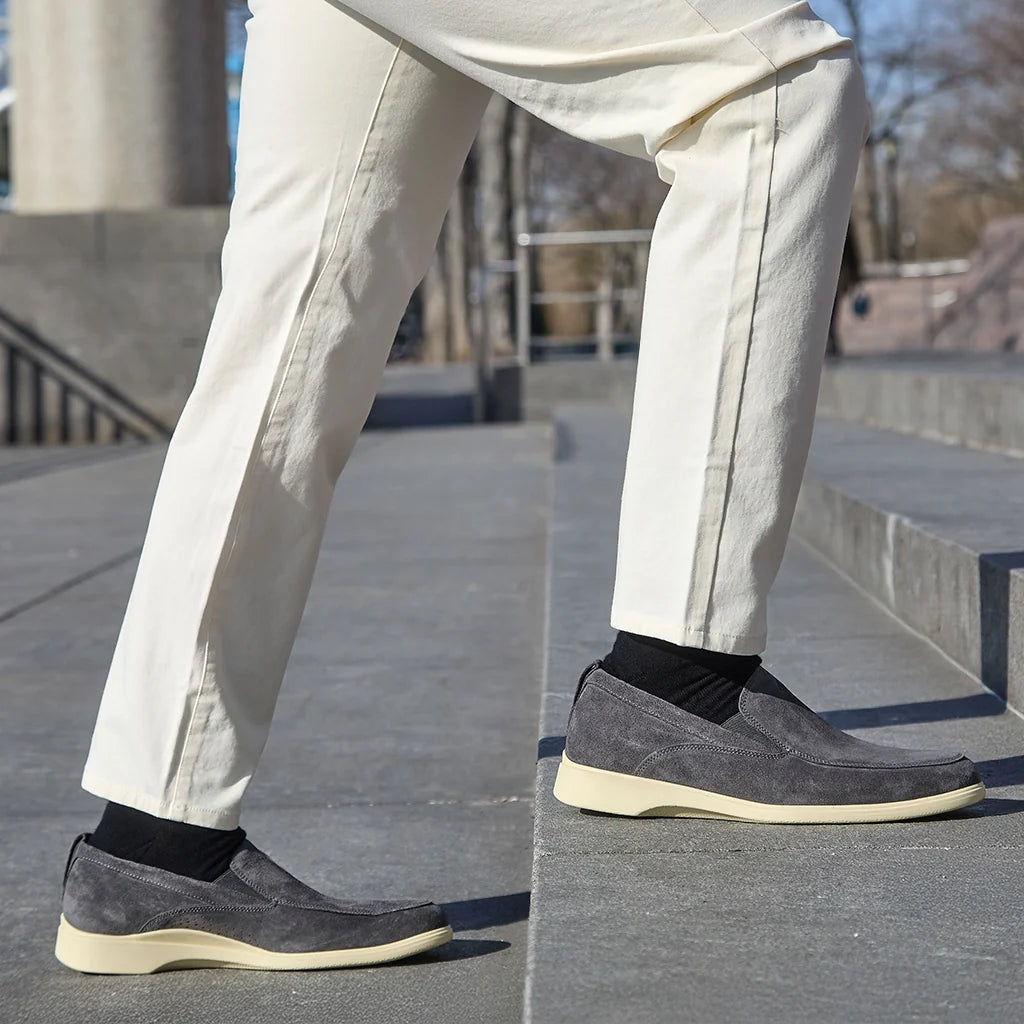 Person wearing gray shoes and beige pants on a concrete surface.