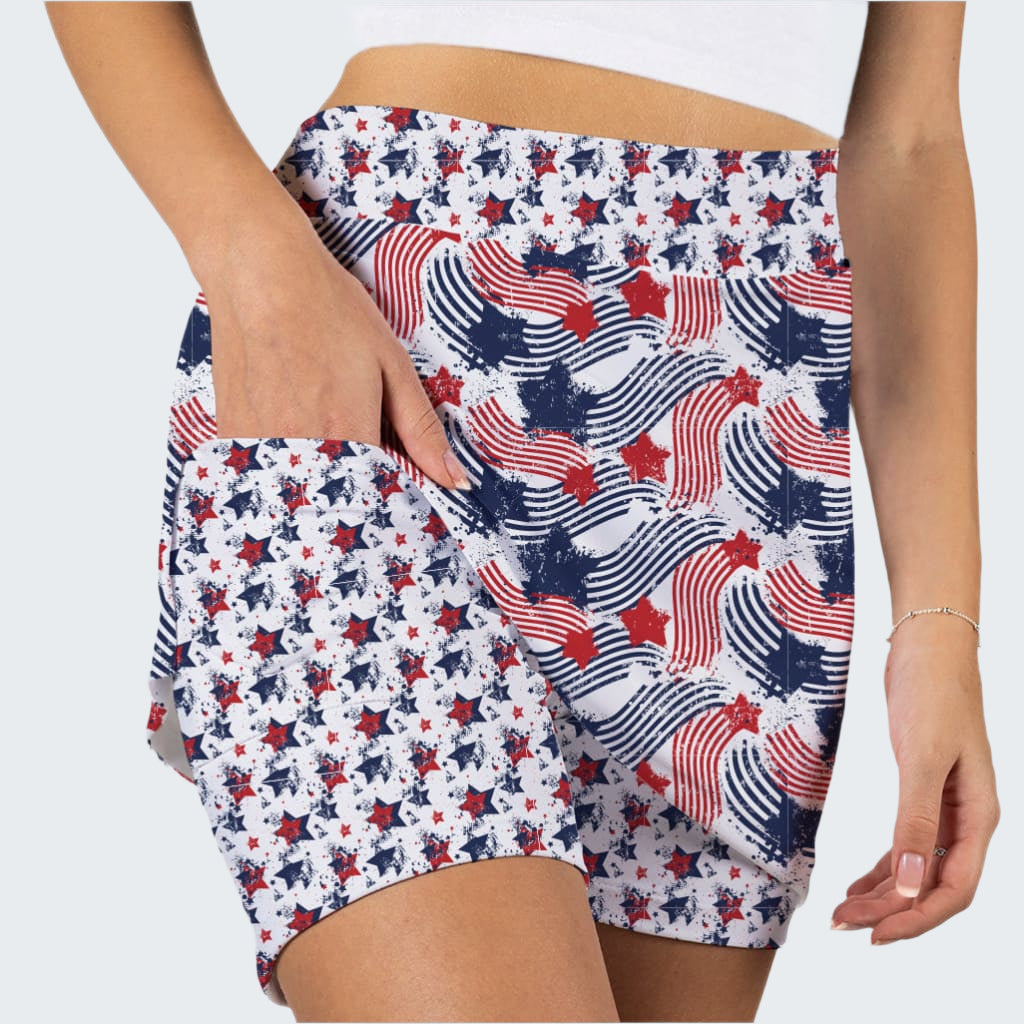Person wearing a pair of shorts with a red, white, and blue pattern on a plain background