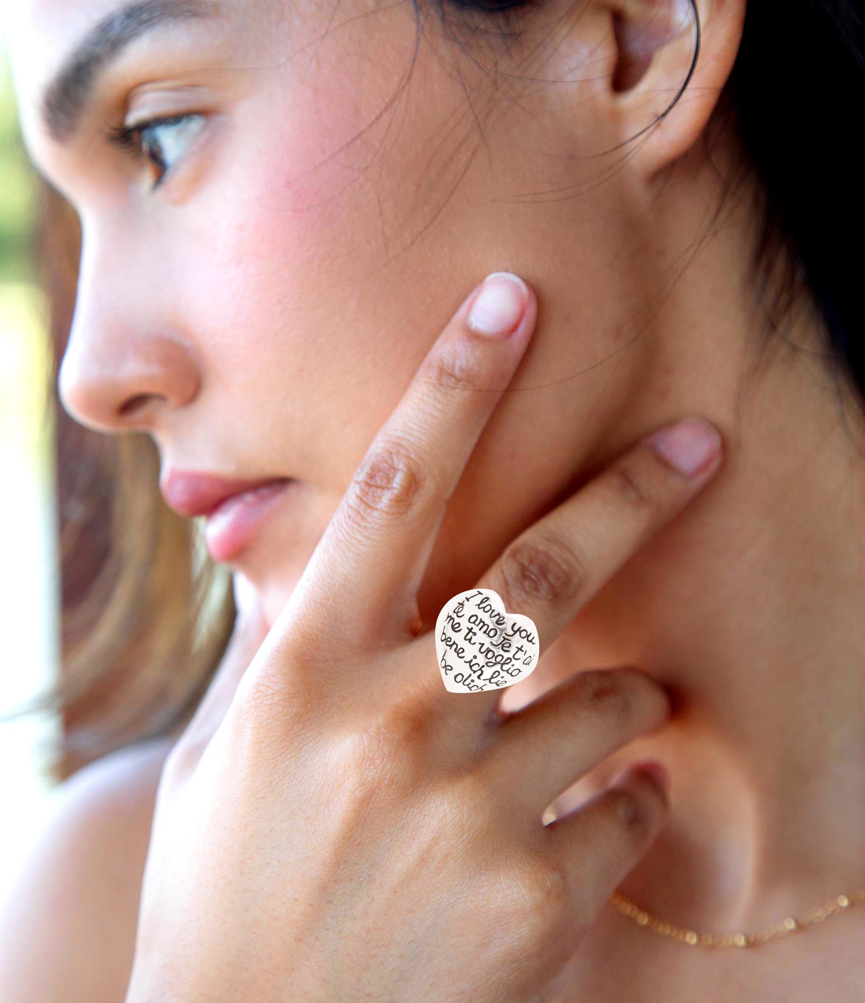 Close-up of a woman wearing a silver ring with a diamond design.