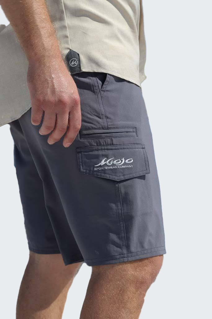 Person wearing gray shorts with a brand logo on a white background