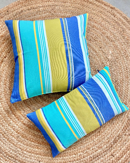 Two striped pillows on a woven mat