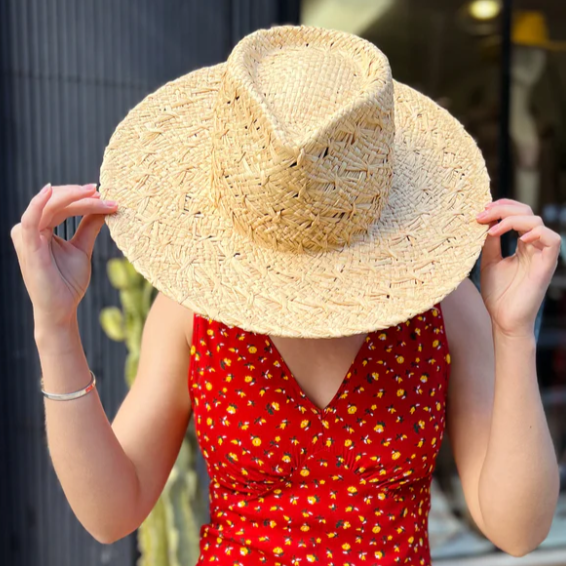 Person wearing a straw hat and red dress with yellow pattern