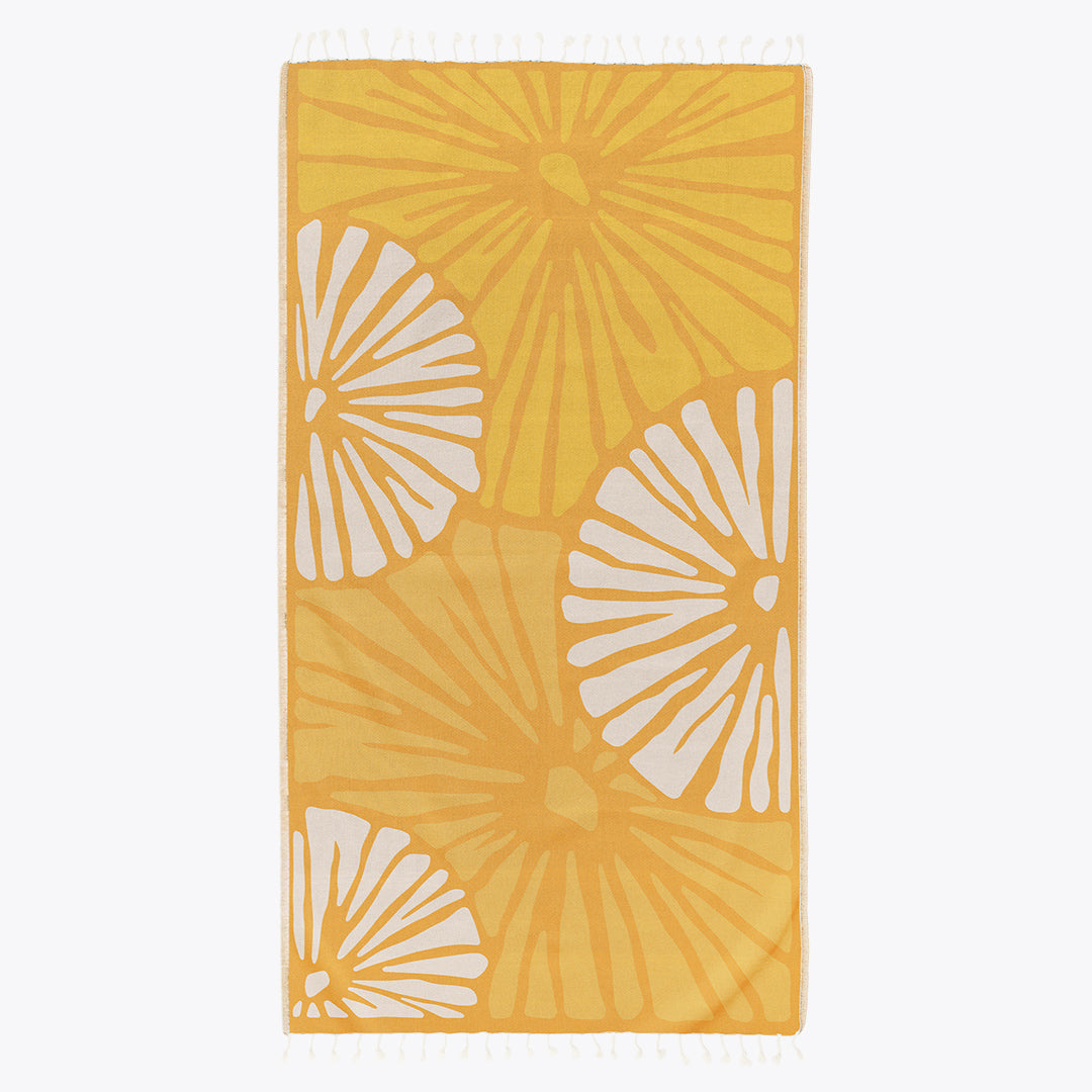 Yellow towel with white floral patterns on a white background