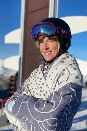 Person wearing a patterned jacket and goggles with a snowy background